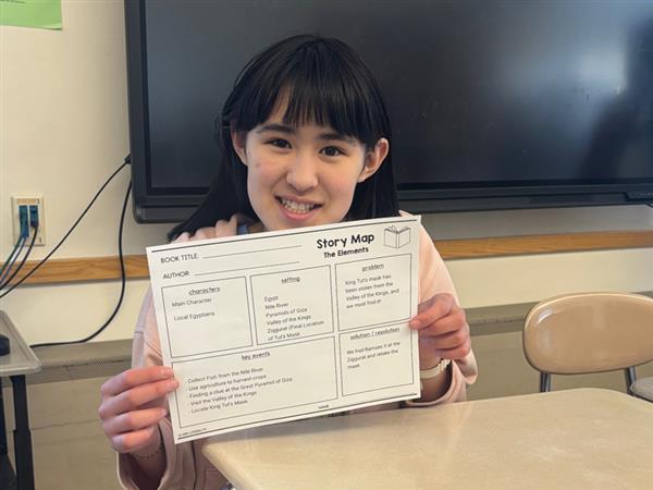 student holding story map