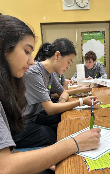 STUDENTS AT TABLE WRITING