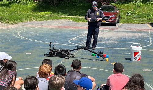 Main Street School fifth grade students watching Police Detective Thomas Barker and his hazmat robot