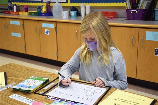 student working on math worksheet